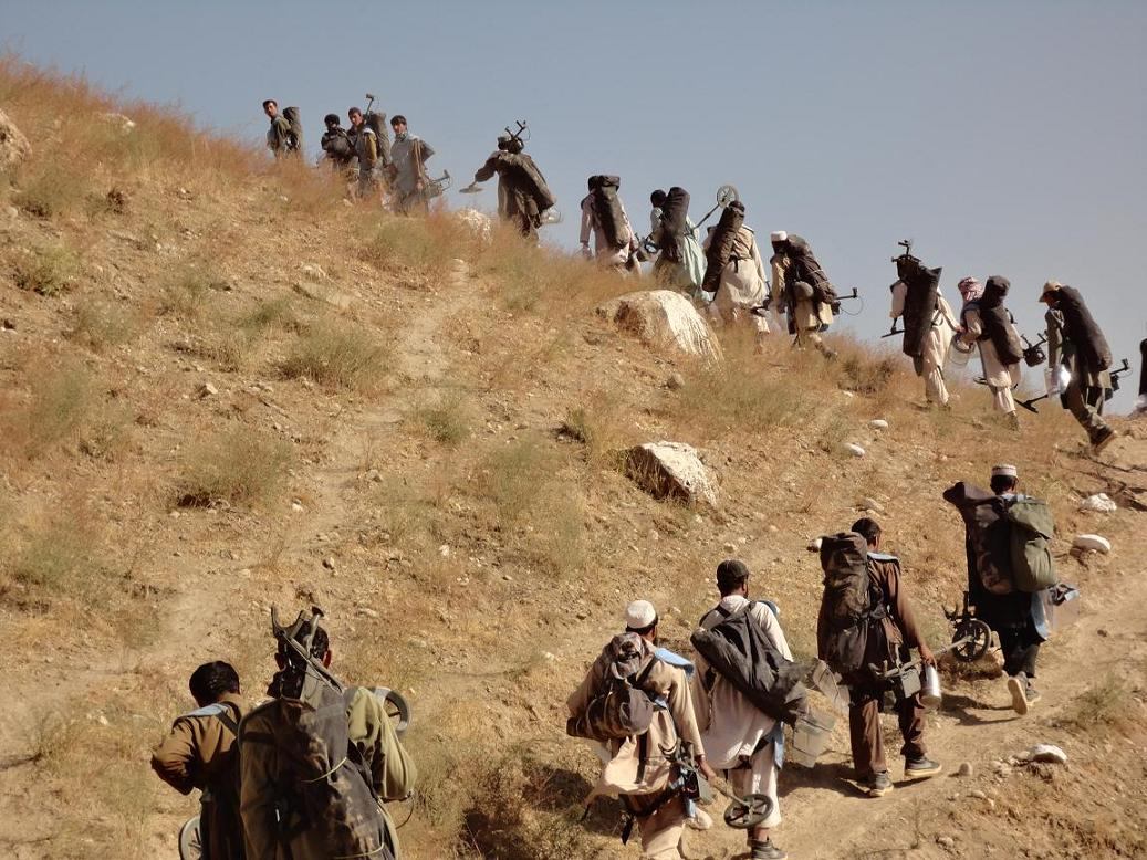 An MCPA demining team walking in single file to the work site